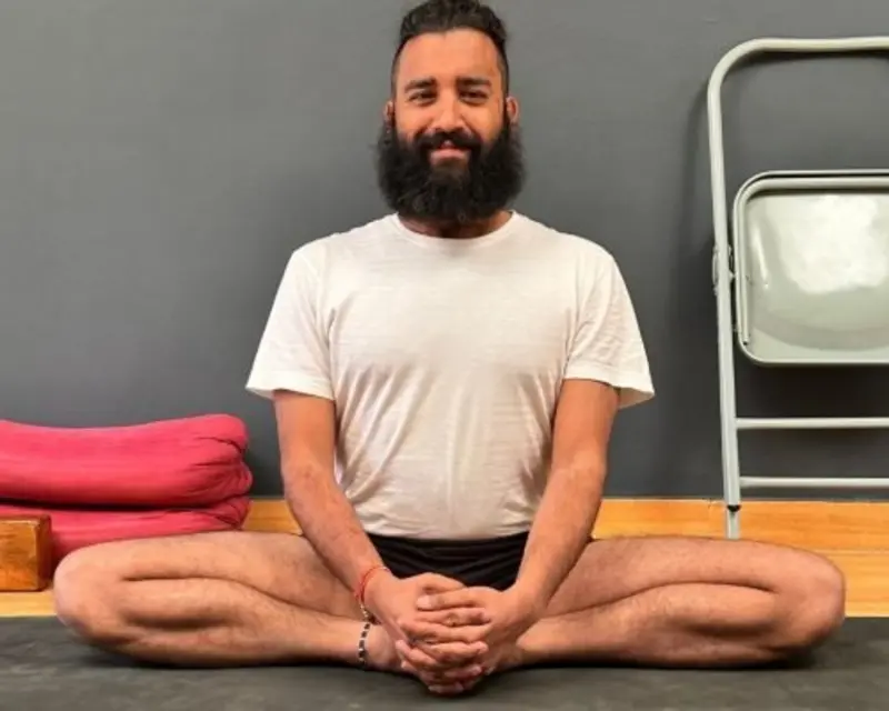 Yoga teacher seated in a calm meditative pose for 1-on-1 sessions
